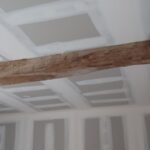 plafond blanc en construction avec joint apparent et une poutre