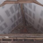 Détail de la rénovation intérieure avec poutre en bois massif au-dessus d'une ouverture murale encadrée pour rénovation